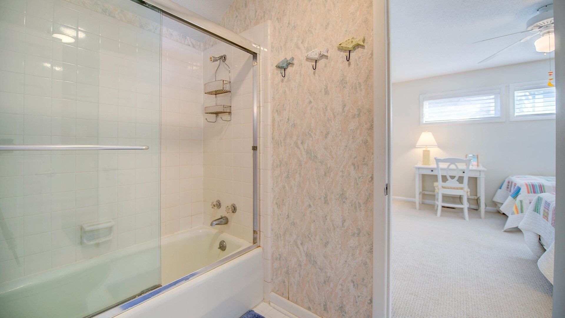 A bathroom with a glass shower enclosure, a bathtub, and a vanity with a mirror.