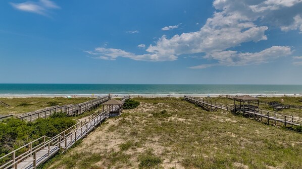 A beach with wooden walkways and a grassy area leading to the ocean. - Spectacular Oceanfront Home Located On North Litchfields Peaceful And Pristine Beaches. 6 Bedroom Home by Peace Vacations (Pawleys Island)