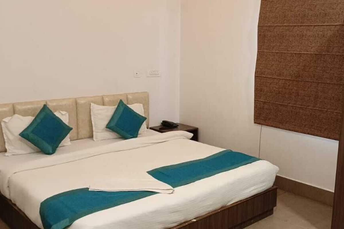 Une chambre à coucher avec un lit, deux oreillers, une table de chevet et une armoire.