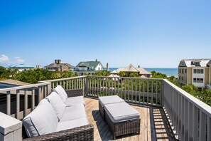 A balcony with wicker furniture and a view of the ocean. - Natural And Serene Home Away From Home 5 Bedroom Home by Peace Vacations (Georgetown)