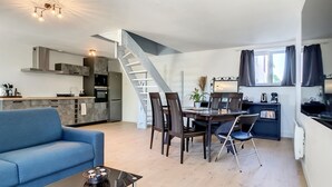 Un appartement moderne comprenant un coin repas, une cuisine et un salon.