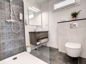 Une salle de bain moderne équipée d’une douche, de toilettes et d’un lavabo.
