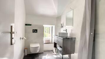 Ein modernes Badezimmer mit Toilette, Waschbecken und Dusche.