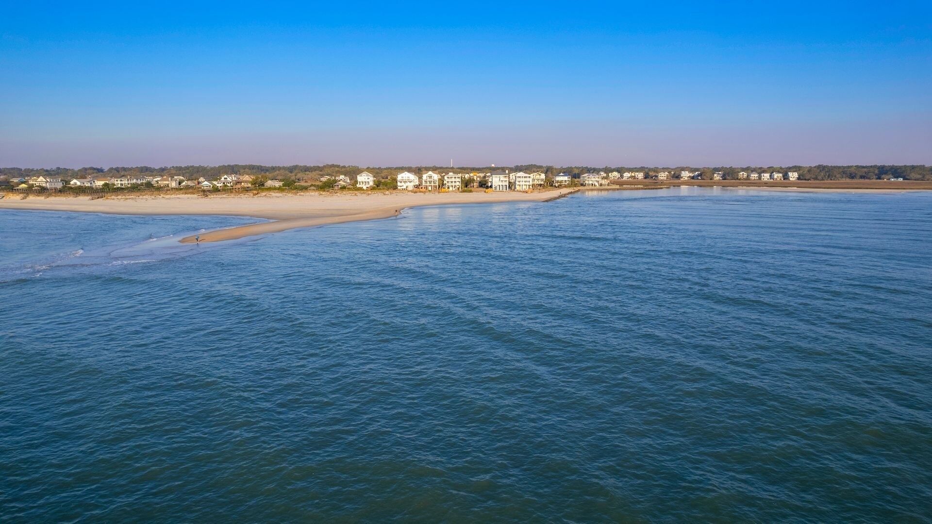 Une zone côtière avec une plage et des bâtiments le long du rivage.