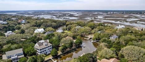 Vista aérea de una zona residencial con casas rodeadas de vegetación densa y un río.