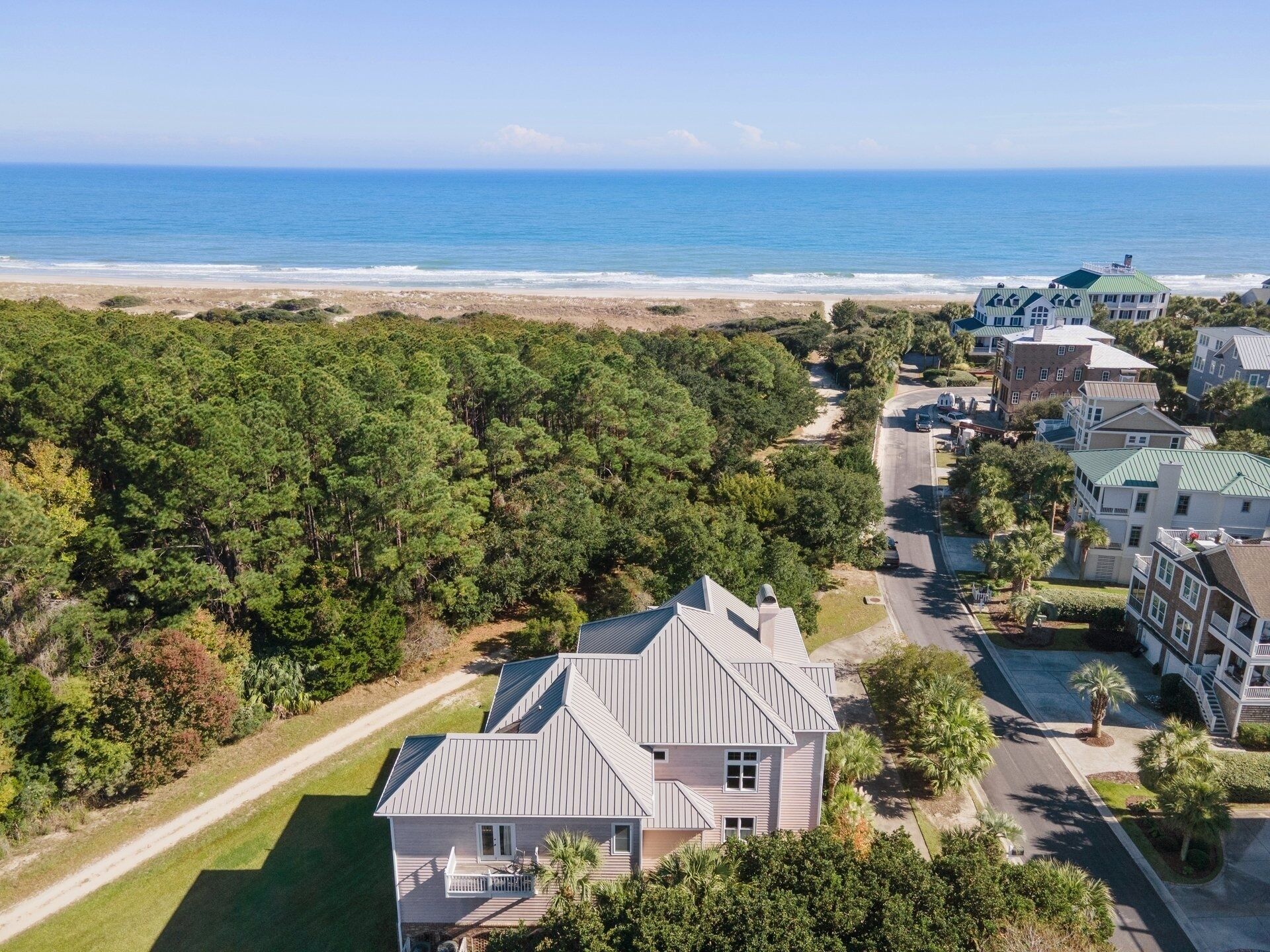 A coastal residential area with houses, a beach, and a forested area.