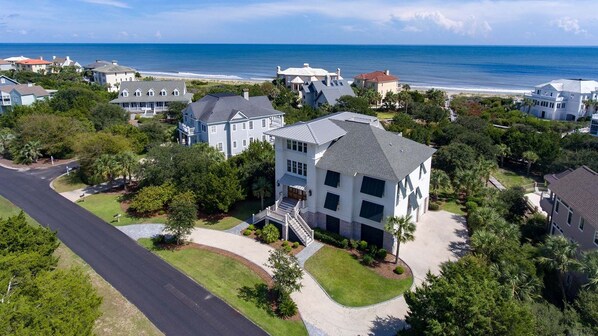A residential area with houses, a road, and a beach in the background. - Exquisite Oceanfront Home Perfect For A Family Getaway 6 Bedroom Home by Peace Vacations (Georgetown)
