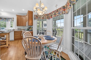 A kitchen with wooden cabinets, a dining table with chairs, and a chandelier.