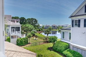 A residential area with houses, a lake, and a well-maintained lawn.