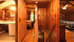 A wooden cabin interior with a kitchen, a bathroom, and two bedrooms. - Traditional Waterfront Maine Cottage on Long Lake with great swimming. (Naples)
