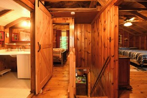 A wooden cabin interior with a kitchen, a bathroom, and two bedrooms. - Traditional Waterfront Maine Cottage on Long Lake with great swimming. (Naples)
