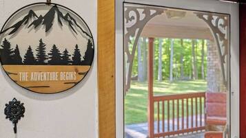 A circular wall decoration with a mountain and forest silhouette, and the text 'THE ADVENTURE BEGINS' below it.