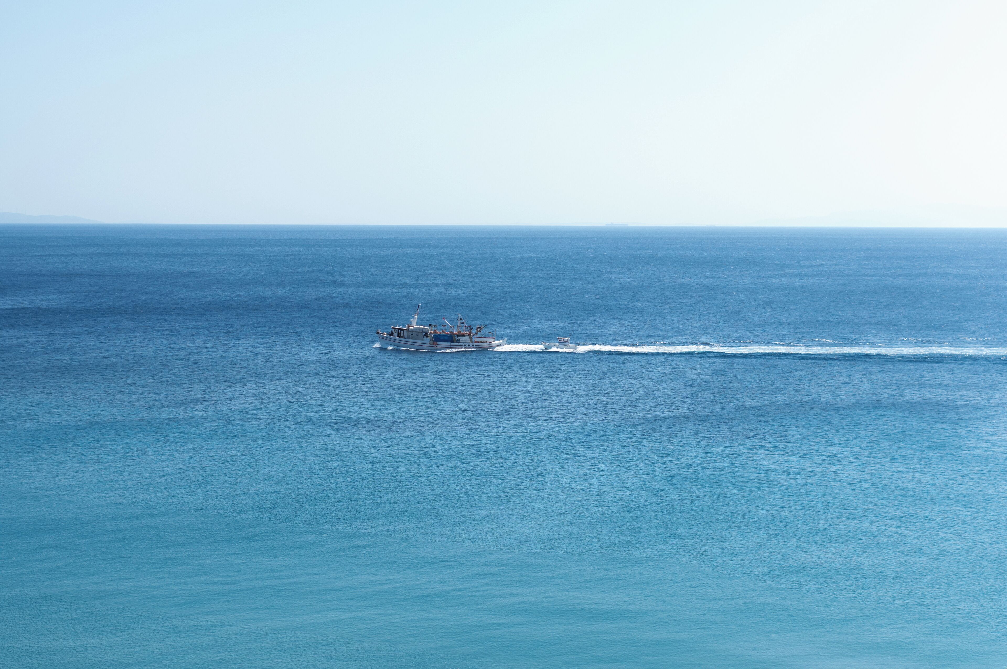 A boat moving across a calm sea.