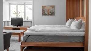 A bedroom with a bed, a TV, a desk, and a window. - Perfect located Apartment in the heart of Södermalm (Stockholm)