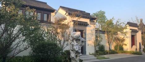 Un edificio tradicional con tejado de tejas, un camino de piedra y un césped bien cuidado.