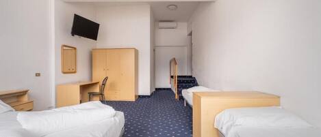 A hotel room with two single beds, a desk with a chair, a TV mounted on the wall, and a mirror.