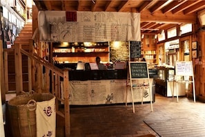 A wooden interior with a counter, menu boards, and a staircase. - Lijiang Shuhe K2 International Youth Hotle (Lijiang)
