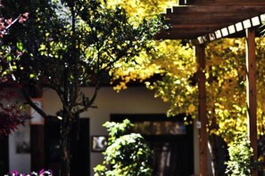 A wooden pergola structure with a view of a building in the background. - Lijiang Shuhe K2 International Youth Hotle (Lijiang)