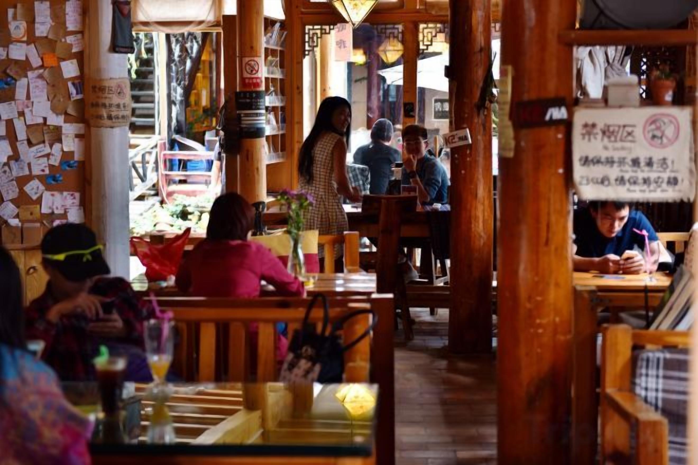 A restaurant interior with wooden furniture, tables, and chairs.