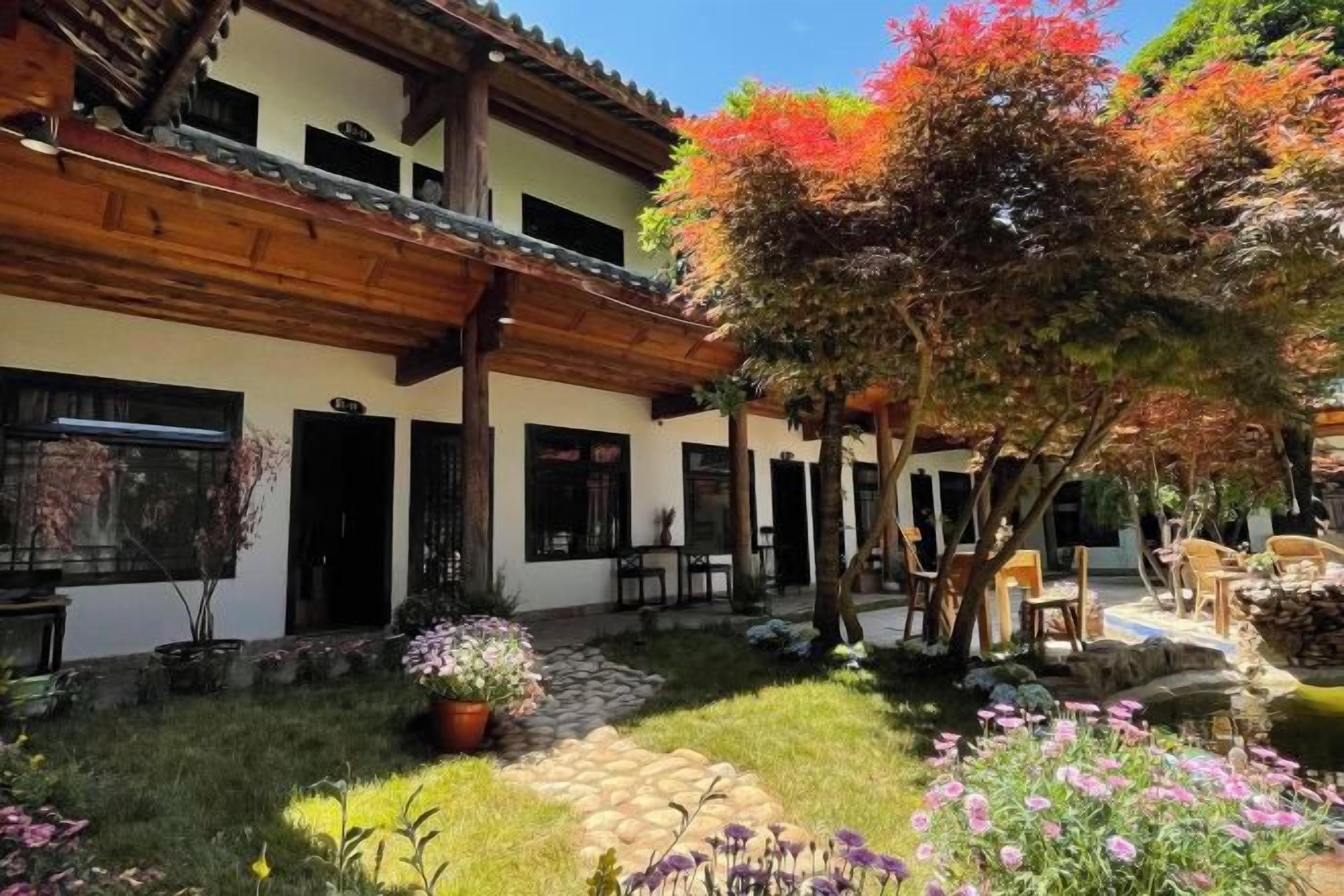 A courtyard with a building, outdoor seating, and a garden.