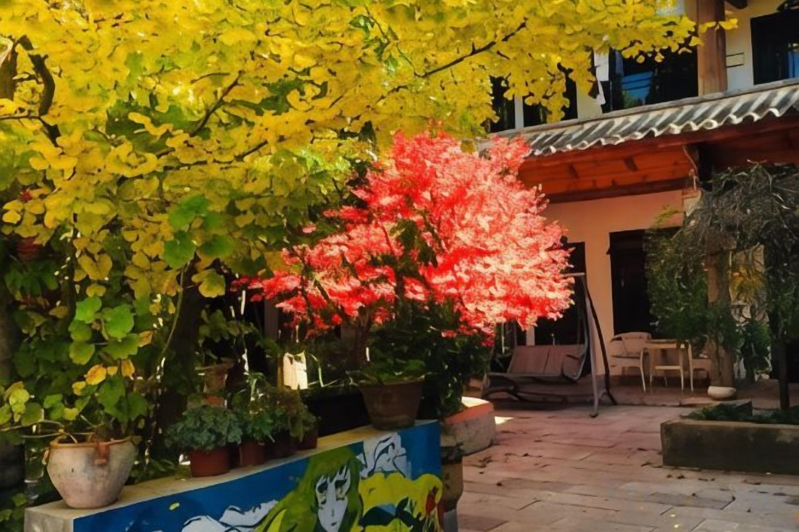 A courtyard with potted plants and a mural on the wall.