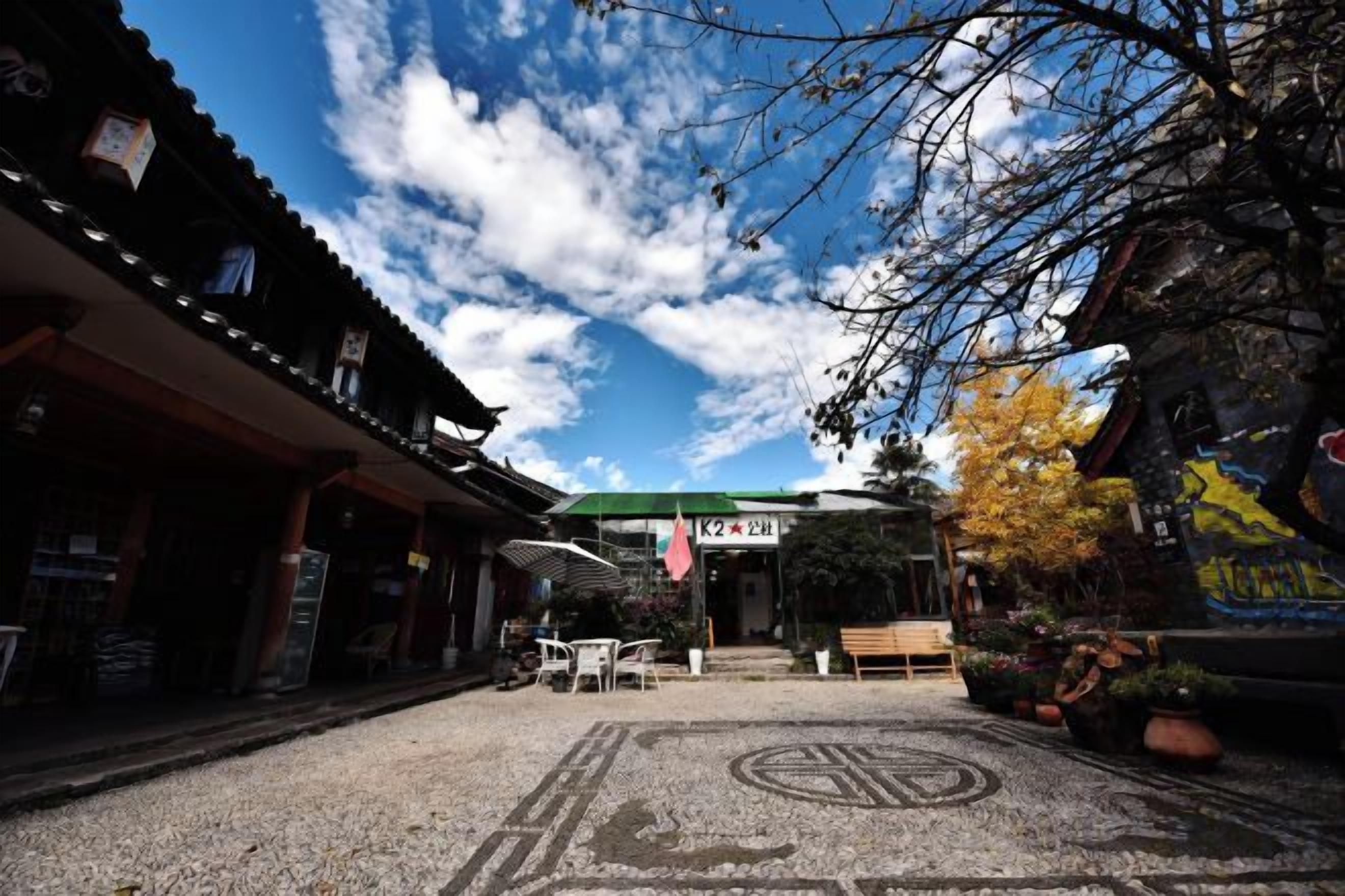 Un edificio japonés tradicional con un corredor cubierto, un letrero y un suelo con diseño.