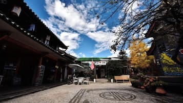 Un edificio japonés tradicional con un corredor cubierto, un letrero y un suelo con diseño.