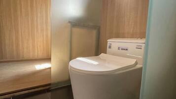A white toilet in a bathroom with wooden paneling on the walls and a tiled floor.