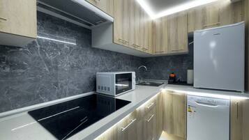 Een koelkast, een magnetron, een kookplaat, een vaatwasser