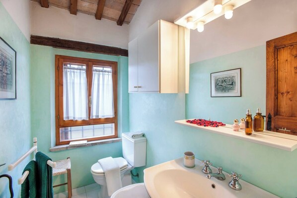 A bathroom with a toilet, sink, and window with curtains. - Villa Deda 12&2 by Marche Holiday Villas (Saltara)