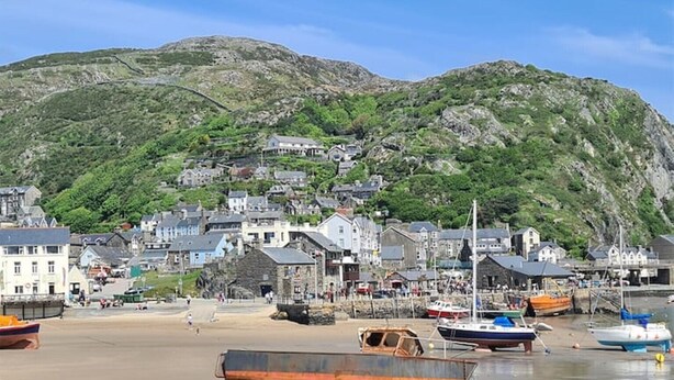 A coastal town with buildings, boats, and a beach.