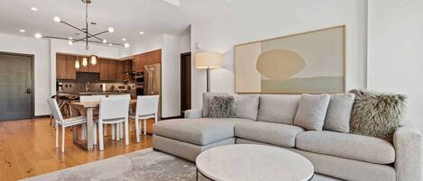 Un salon moderne avec un canapé, une table basse et un coin repas.