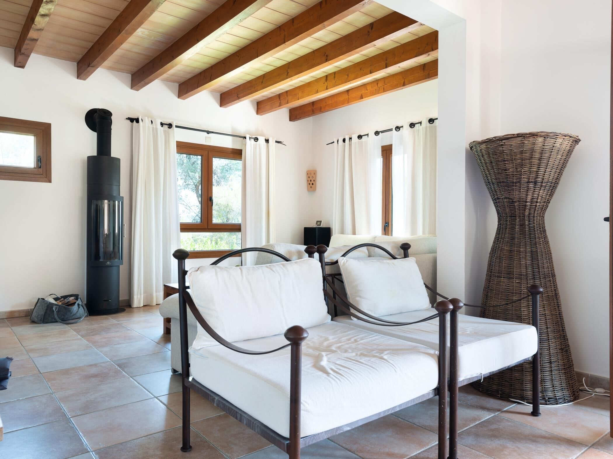 Une chambre confortable avec un lit, une cheminée et une grande fenêtre.