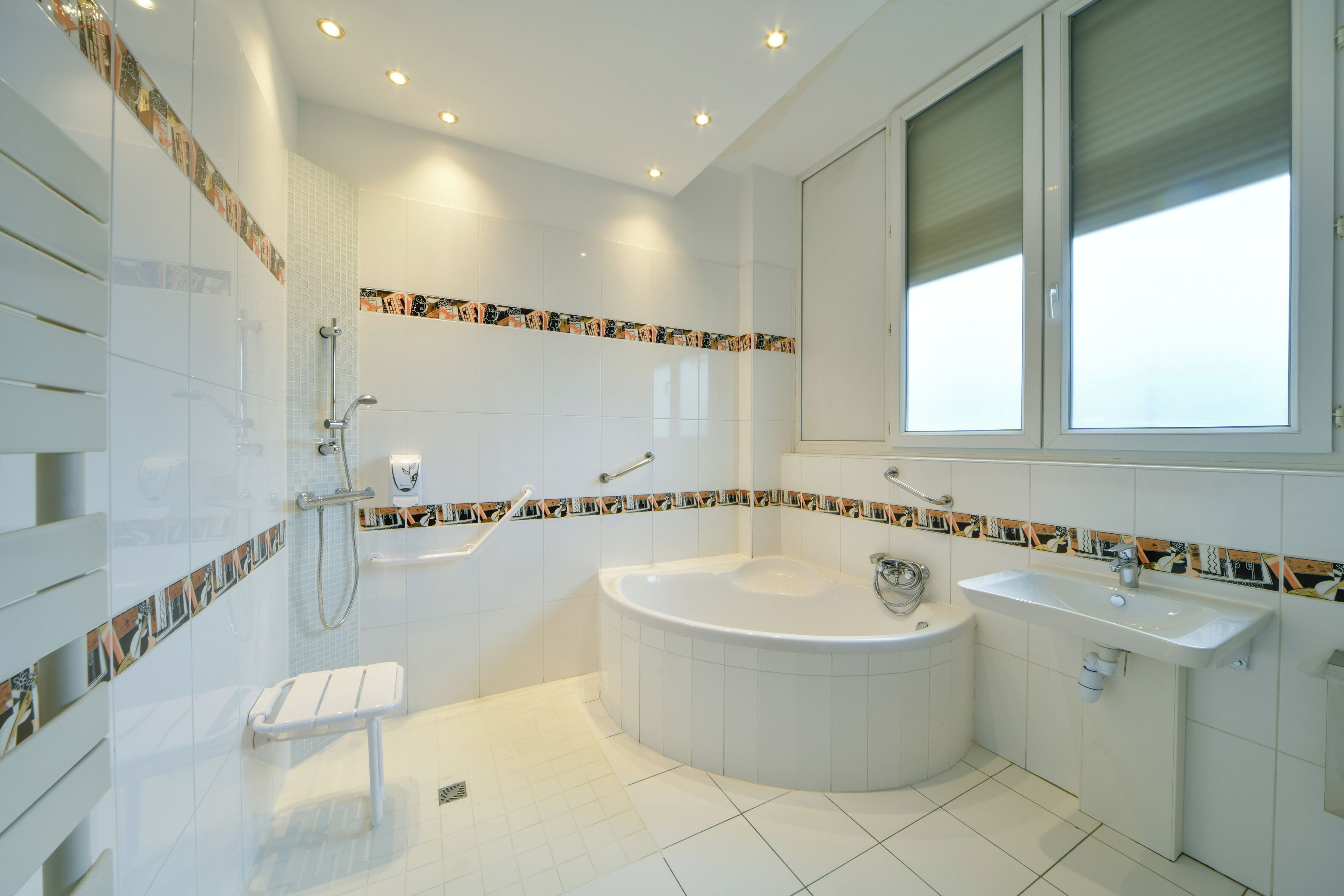 A modern bathroom with a large bathtub, a separate sink, and a shower area.