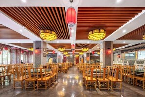 A spacious restaurant with wooden tables and chairs, red lanterns, and a polished floor. - Dunhuang Tianqin Yunshui Hotel (Dunhuang)