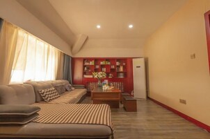 Una sala de estar con un sofá, una mesa de centro y una estantería.