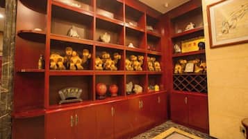 A room with a red wooden cabinet containing various items.