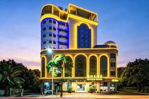 A multi-story hotel with a distinctive curved facade, large windows, and a visible sign indicating it is a hotel.