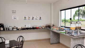 Una cocina con encimera de granito, cafetera y vistas al exterior a través de un amplio ventanal.