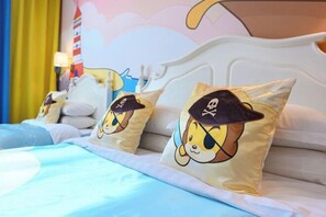 A bed with a white headboard, blue bedding, and three pillows with cartoon characters. - Xuzhou Amusement Land Resort Hotel (Xuzhou)