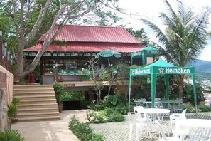 A Heineken establishment with outdoor seating and a red-roofed building. - Grand Mandarin Betong Hotel (Betong)
