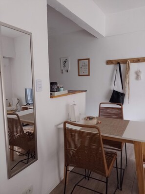 Cozy retreat with a dining table, mirror, and shelf, perfect for a compact stay.