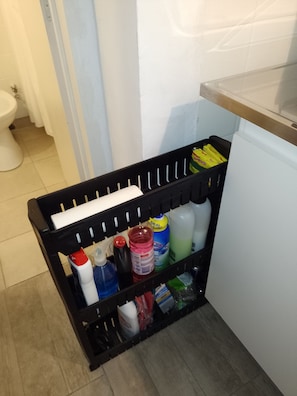 Compact kitchen area with a storage rack and white countertop.