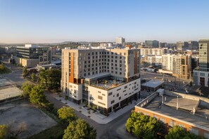 Un hôtel moderne doté d’un jardin sur le toit, entouré d’autres immeubles.