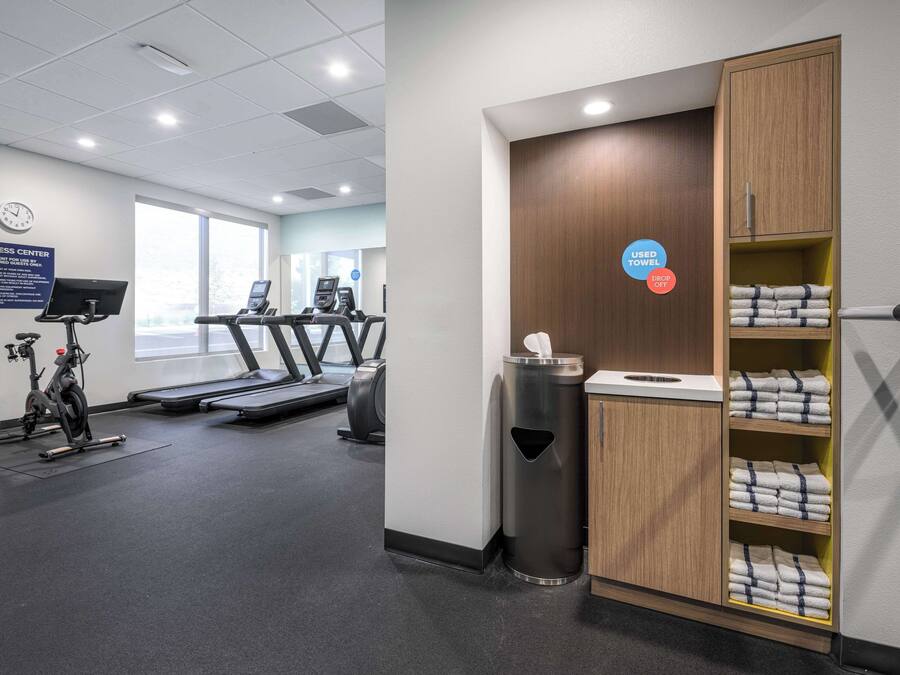 A fitness center with treadmills, an elliptical, and a wall clock.