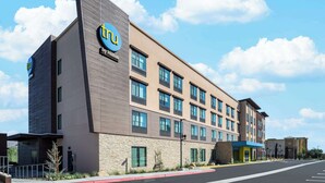 A modern hotel building with a 'TRu by Hilton' sign, multiple windows, and a parking lot. - Tru by Hilton Norco Eastvale (Norco)
