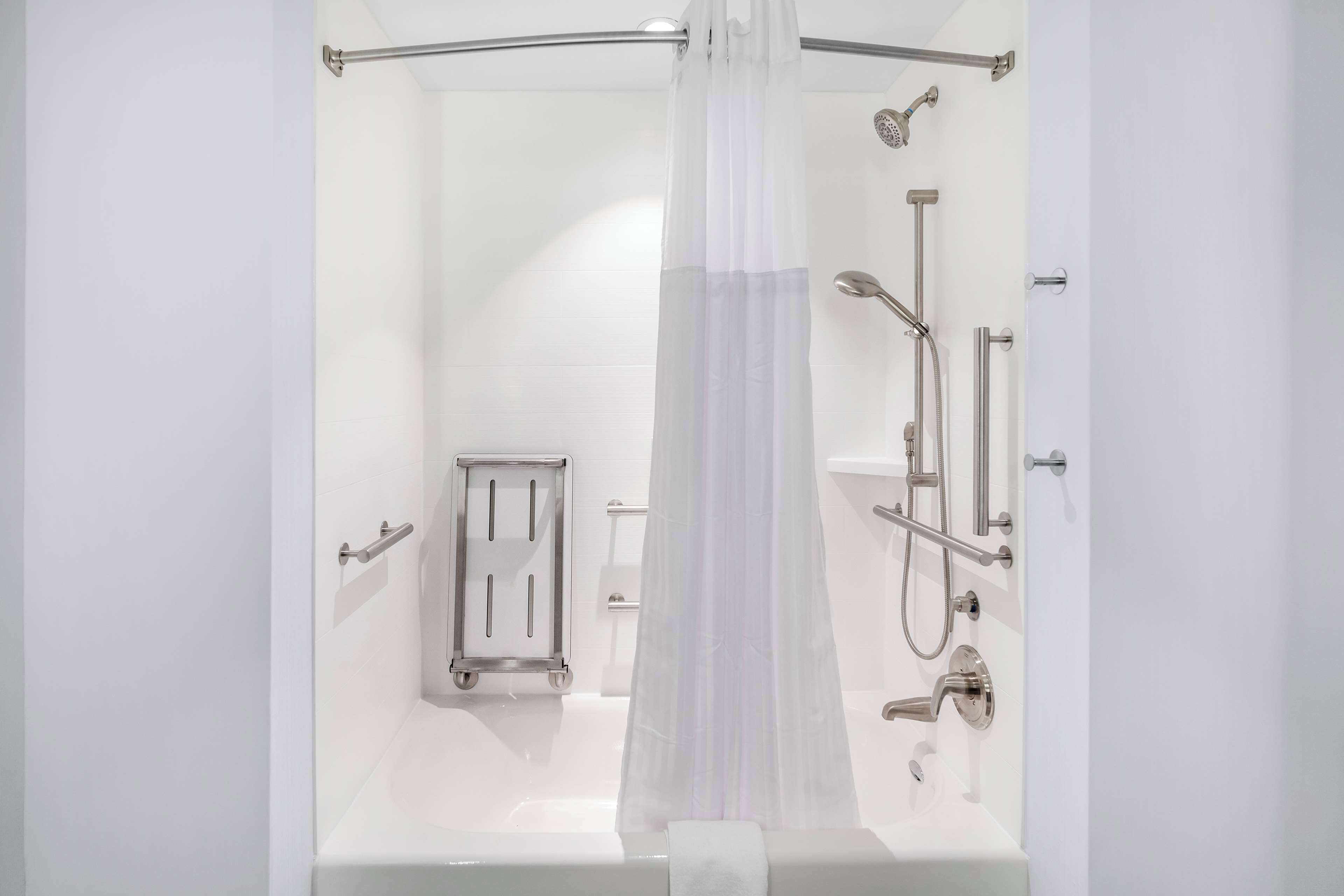 A modern bathroom with a bathtub, shower, and toilet.