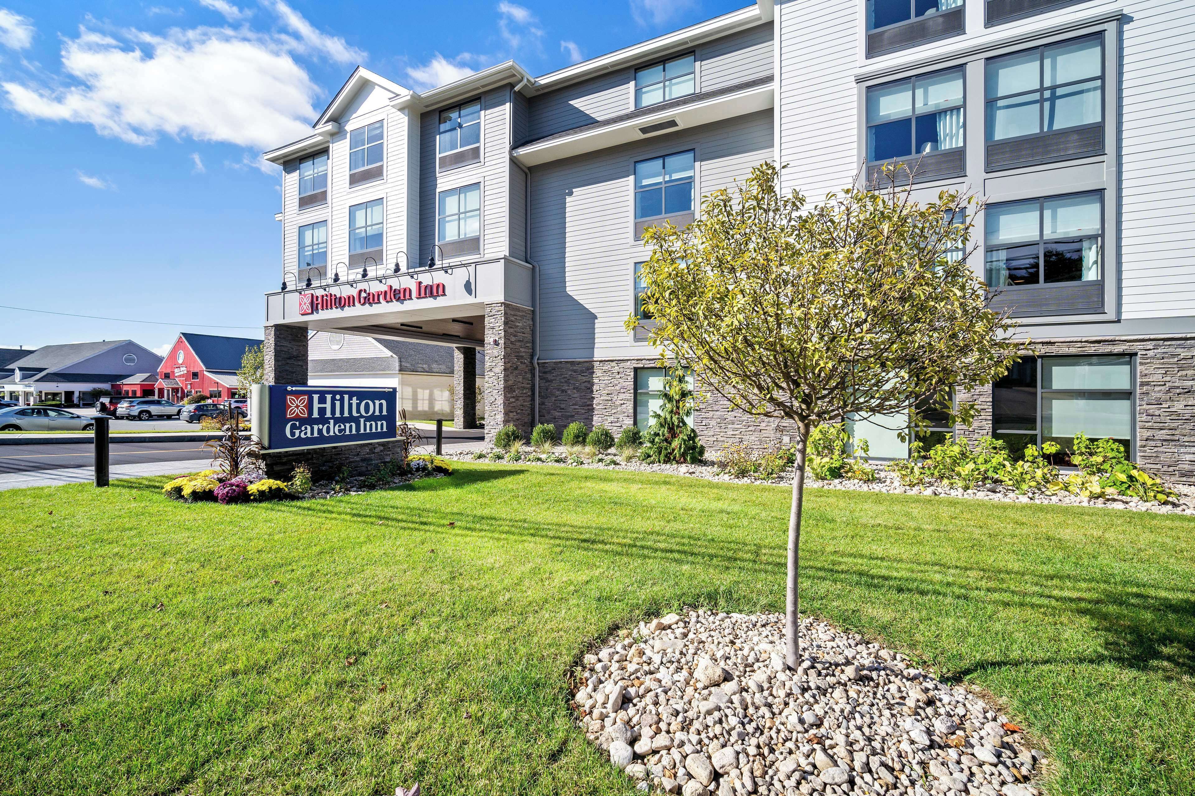 A Hilton Garden Inn with a modern design, featuring a stone facade and large windows.