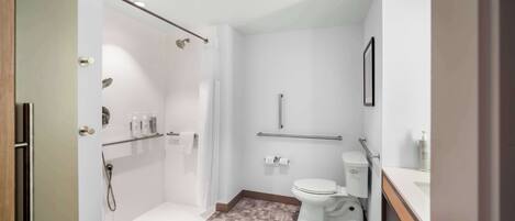 A modern bathroom with a shower, toilet, and sink.