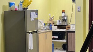 A compact kitchen with a refrigerator, microwave, and coffee maker.